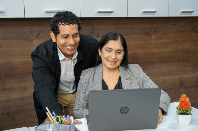 Atención personalizada en oficina de Coopac San Miguel, brindando asesoría cercana y clara a socia desde una laptop