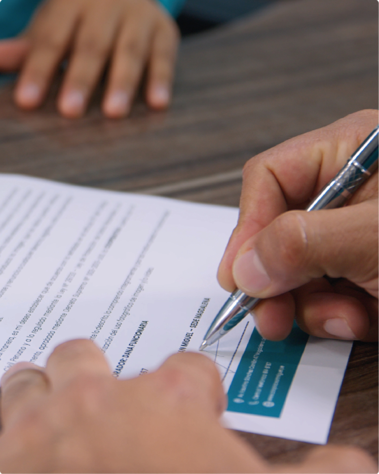 Persona firmando contrato para obtener Préstamo por Descuento por Planilla en Coopac San Miguel