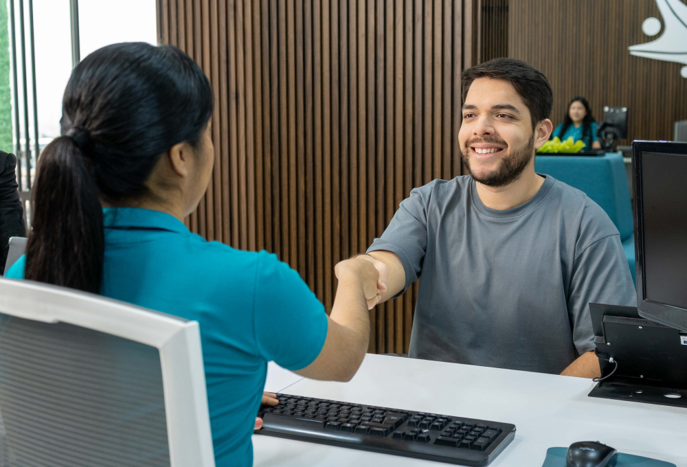 Colaboradora de Coopac San Miguel estrechando la mano de un socio en oficina moderna, representando cordialidad incluso ante errores o problemas como el error 404