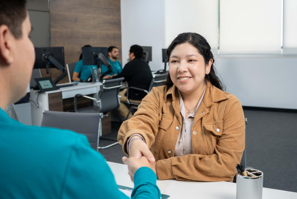 Socia de Coopac San Miguel es atendida con confianza en una oficina moderna como parte del programa Emprende Mujer