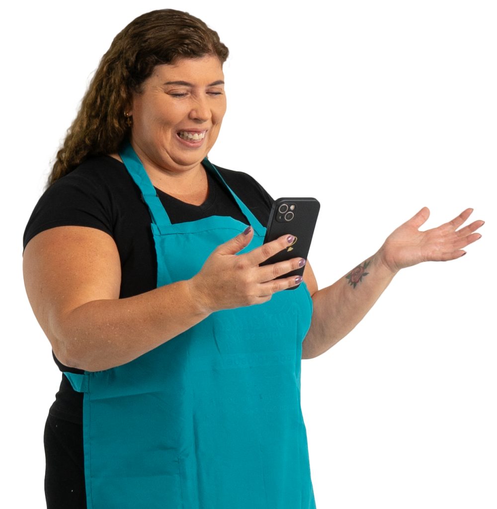 Mujer emprendedora con mandil turquesa revisando su celular con una expresión de duda y sorpresa, representando la sección de preguntas frecuentes de Coopac San Miguel