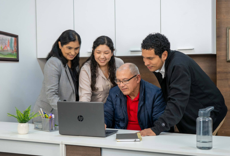 Grupo de asesores de Coopac San Miguel brindando orientación personalizada a emprendedor sobre los beneficios y condiciones del Préstamo para Pequeña Empresa, en ambiente de oficina colaborativa
