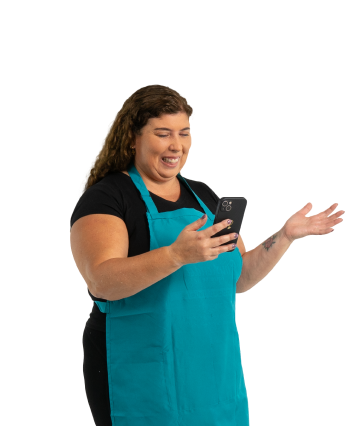 Mujer emprendedora usando su celular con entusiasmo mientras recibe asistencia desde la app de Coopac San Miguel, ideal para resolver dudas frecuentes sobre productos financieros