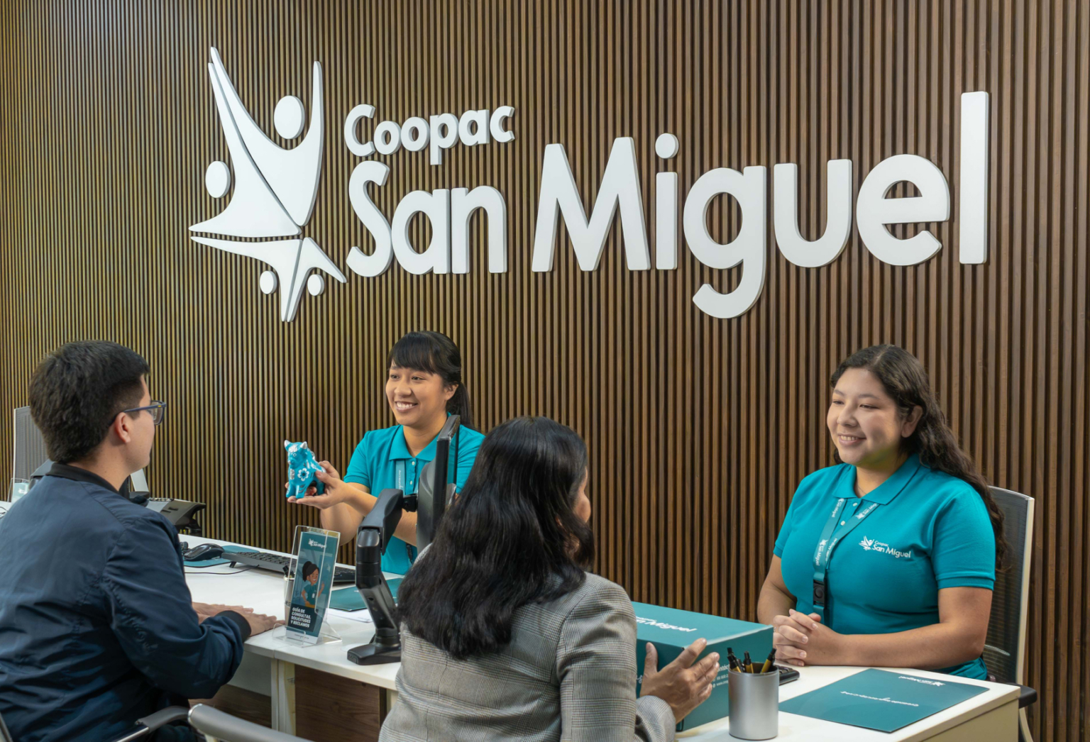 Asesora de Coopac San Miguel brindando información a socios sobre los requisitos y beneficios del Préstamo Multioficio, en una atención personalizada en ventanilla