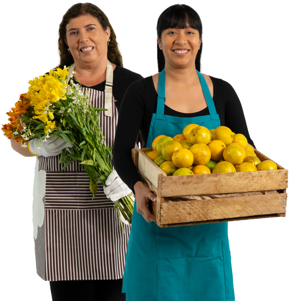 Dos mujeres emprendedoras con mandiles, una con flores y otra con frutas, representando el Préstamo Emprende Mujer de Coopac San Miguel