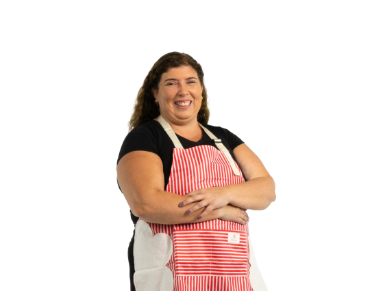 Ama de casa orgullosa y segura de sí misma usando un delantal de cocina, representando a las socias de Coopac San Miguel que acceden a créditos y beneficios para su bienestar familiar