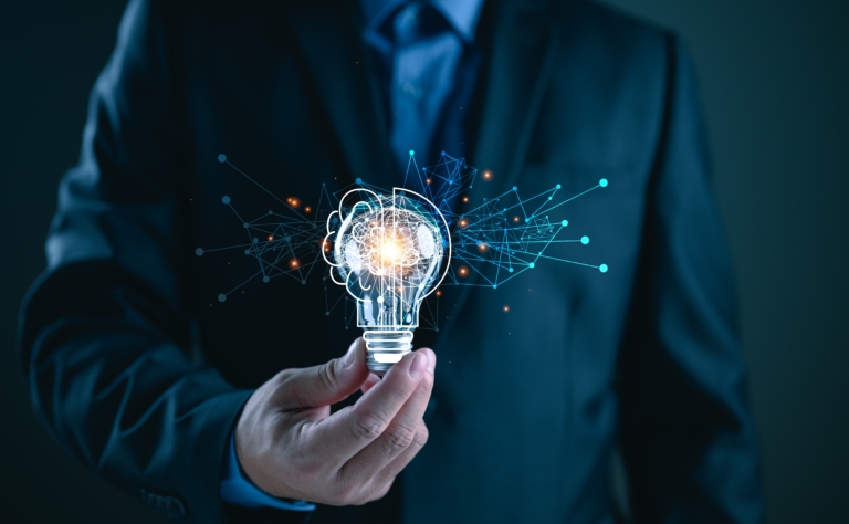 Ejecutivo con foco de luz en forma de cerebro simbolizando ideas financieras para empresas con Coopac San Miguel